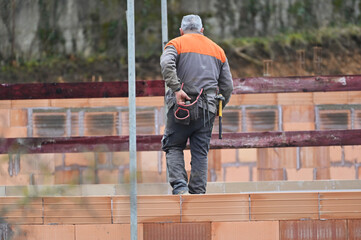 ouvrier maçon posant des briques sur un chantier de construction - 752152061