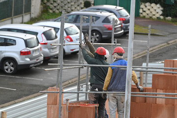 ouvrier maçon posant des briques sur un chantier de construction - 752152073