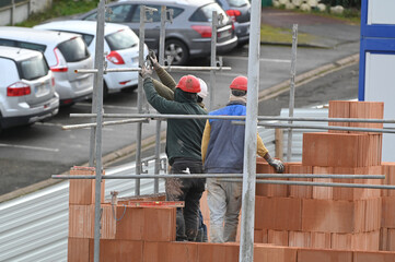 ouvrier maçon posant des briques sur un chantier de construction - 752152088