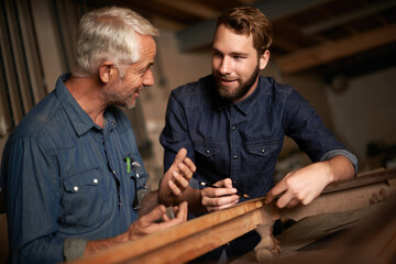 Carpenter, mentor and furniture building in workshop, learning and talking in small business...