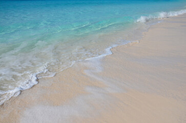Soft blue ocean wave or clear sea on clean sandy beach
