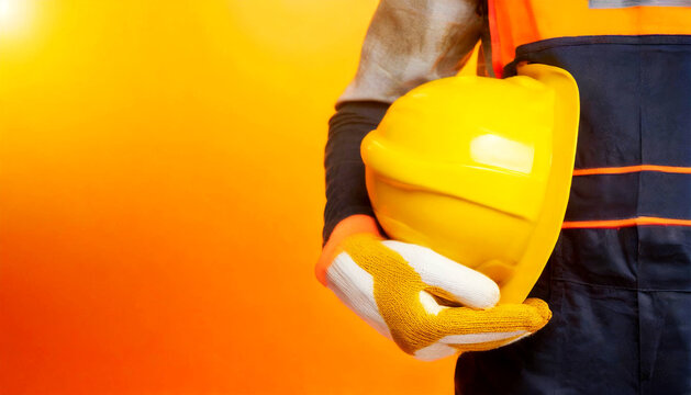 Manual worker with protective work gloves holding a yellow safety helmet on a yellow and orange background with copy space. Concept of workplace security. Generative Ai.