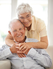Couple, senior and hug or portrait on couch, home and relax together for bonding and smile. Elderly...