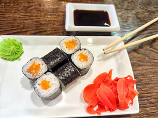 Sushi rolls with fresh ingredients served on a platter. Japanese Sushi Rolls on White Plate With Ginger Garnish. Blurred and Partial focus