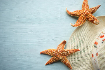 Hat and starfishes on wooden background - summer vacation concept