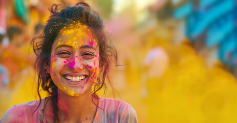 Holi festival. Widescreen banner with copy space. Joyful indian young woman celebrating Holi.