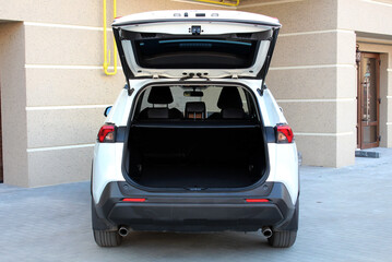 New white SUV open trunk. Modern car SUV with open empty trunk. Modern wagon car open trunk. Car boot is open.