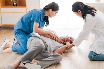 senior patient falling on the ground floor at home, Asian caregiver helping elderly older male from...