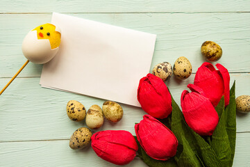 Red tulips and quail eggs on wooden background. Easter concept