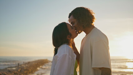 Tender couple kissing at evening coast close up. Woman man with love on sunset