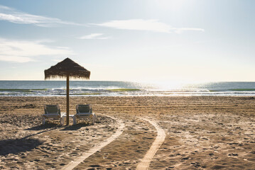 the sun shines over a sandy beach and beach umbrella
