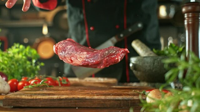 Super Slow Motion of Flying Raw Beef Steak on Cutting Board. Camera Placed on High Speed Cine Bot. Filmed on High Speed Cinema Camera, 1000 fps.