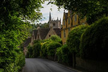 View of beautiful stone village through lush greenery in the English countryside