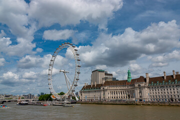 Fototapeta na wymiar Wide River Thames flowing past the London Eye, a popular tourist attraction