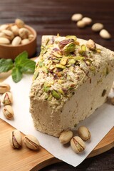 Piece of tasty halva with pistachios on table, closeup