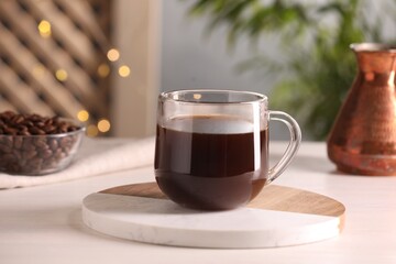 Delicious coffee in cup on white wooden table