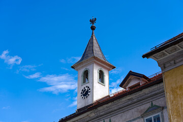 Fototapeta na wymiar Old town of Slovenian City of Kranj with clock tower and eagle coat of arms on a sunny summer day. Photo taken August 10th, 2023, Kranj, Slovenia.