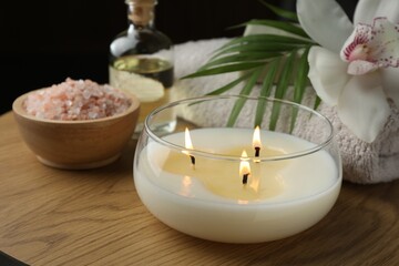 Composition with different spa products and burning candle on wooden table