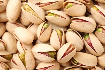 Tasty unpeeled pistachios as background, top view