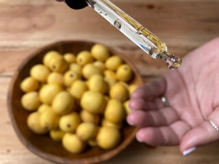 Marula fruit cosmetic oil in a dropper with marula fruit in soft focus