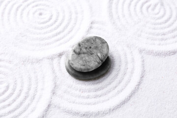 Fototapeta na wymiar Zen garden stones on white sand with pattern, above view