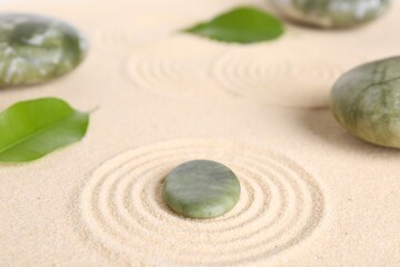 Zen garden stones and leaves on beige sand with pattern