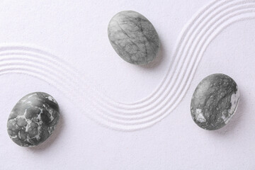 Zen concept. Stones and pattern on white sand, flat lay