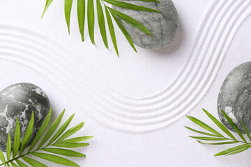 Zen concept. Stones, leaves and pattern on white sand, flat lay