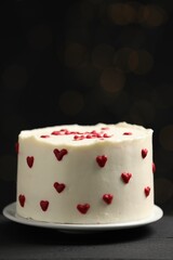 Bento cake with red cream hearts on black table, closeup. St. Valentine's day surprise