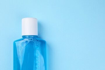 Fresh mouthwash in bottle on light blue background, top view. Space for text