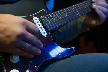Close up hand playing electric guitar. Musician playing guitar, live music. Man playing guitar. Musical instrument. Electric guitar. Repetition of rock music band.