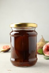 Jar of tasty sweet fig jam on light table