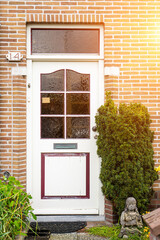 Facade of typical Dutch door house with brick walls, steps, front door windows. Doors on the street, Netherlands