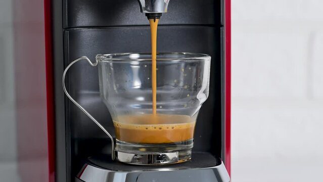 Espresso machine making coffee in glass cup
