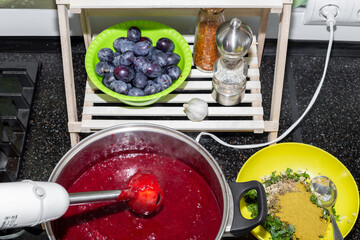 A pan with plum puree whipped with a blender and seasonings for making tkemali sauce, top view