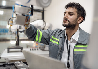 Latino robotic development engineer working robot arm connection control at electronic futuristic science laboratory. Hispanic technician learning innovation machine in automated engineering academy.