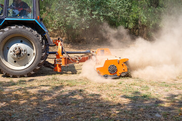 tractor with a mulcher crushes and levels the top layer of soil. Agricultural work