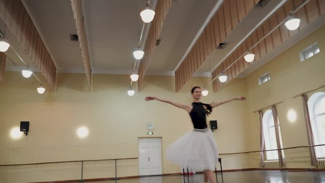 The prima ballerina performs circular movements in the centre of the ballet hall