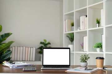 Mock up blank white screen laptop, book and home decor. Sustainability eco friendly lifestyle