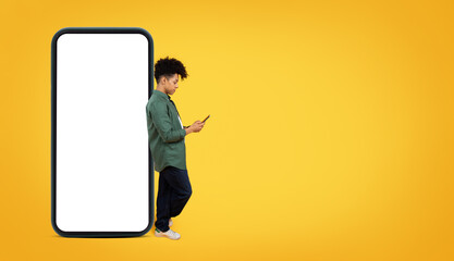 Cool black guy leaning on smartphone with white screen