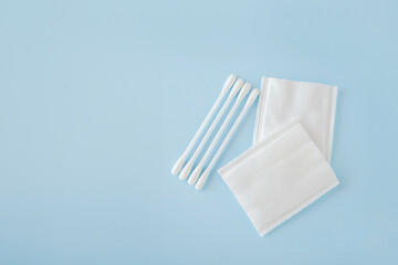 rectangle cotton pads and sticks to remove makeup and cleanse the skin on blue background. Copy...