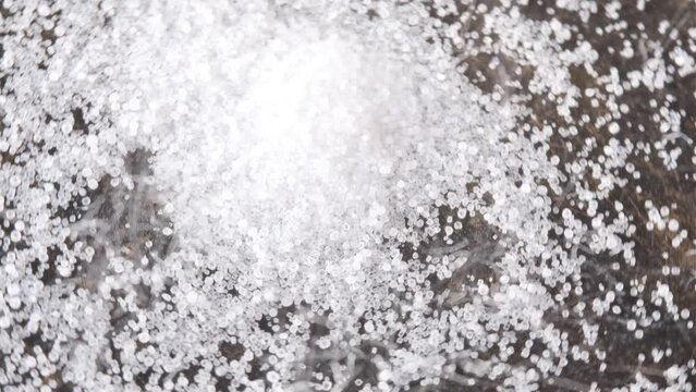 Close-up high detail image of salt grains falling. Salt rotating with close up.