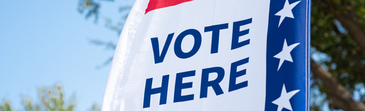 Panorama Vote Here high resolution text on political vote flag banner fiberglass poles, polyester double-sided election decorations polling locations on rotating pole, non-English-proficient, TX. USA