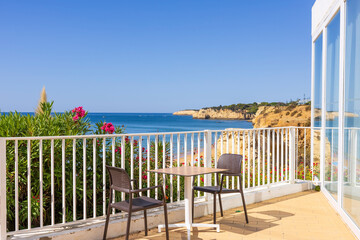 Table and chairs on terrace with sea view, Algarve, Portugal