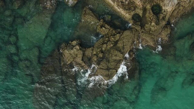 Aerial top view 4k footage by drone of ocean blue waves break on high cliff of a rocky mountain.Dream trip to green island. Outdoor adventure travel to beautiful phuket thiland beach.