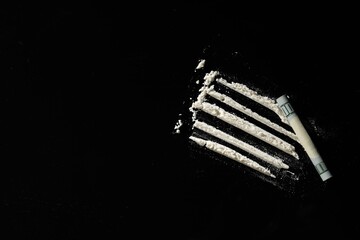 Hard drug and rolled dollar banknote on black background,, flat lay. Space for text
