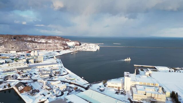 Otaru, Japan: Aerial drone footage of a ship leaving the Otaru harbor in winter in Hokkaido in northern Japan