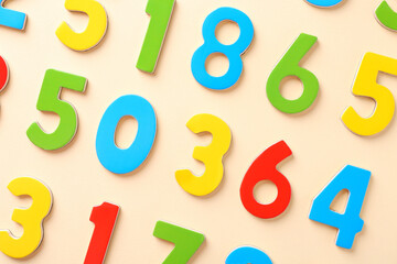 Colorful numbers on beige background, flat lay