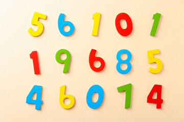 Colorful numbers on beige background, flat lay