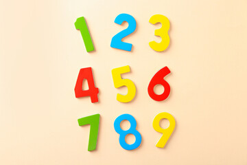 Colorful numbers on beige background, flat lay
